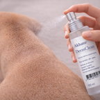 Main pulvérisant DermClean™ sur le pelage du chien pour nettoyer une zone sensible en douceur